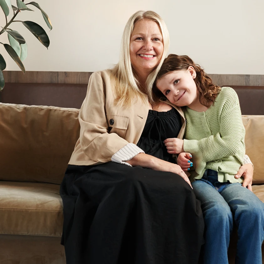 Natalie, living with heart disease, and her mother sitting on a sofa. 
