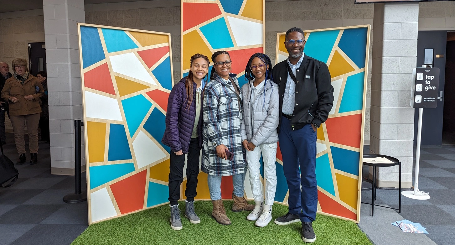 Katherine and her family in front of a large mural.